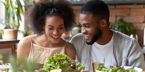 A man and woman are smiling at each other while eating a salad