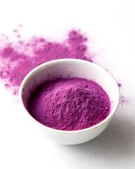 Obraz na płótnie Canvas Organic Purple Sweet Potato Powder in a White Ceramic Bowl. Natural Food Coloring Concept