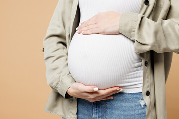 Close up cropped young pregnant expectant woman future mom in grey shirt with belly stomach...