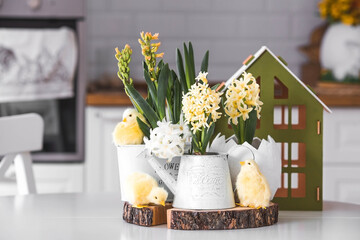 Happy Easter. Spring yellow hyacinth flowers in an egg-shaped vase, chicken chicks on a white...