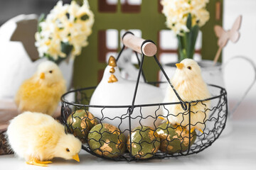Happy Easter. Spring yellow hyacinth flowers in an egg-shaped vase, chicken chicks on a white...