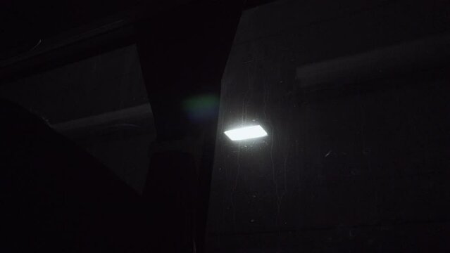 Energy saving lamps dimly illuminate underground tunnel. Light changes quickly to illuminate interior of tourist bus with curtain and comfortable seat while driving. Underground traffic, no people.