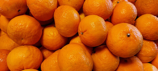 banner of fresh ripe tangerines lying on a market showcase, fruit texture or background