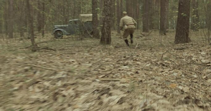 Reenactor Dressed As Russian Soviet Infantry Soldier Attack German Vehicle Truck Opel Blitz In Autumn Forest. Military Truck Opel. German Wehrmacht World War Ii Military Automotive. Reenactment Tactic