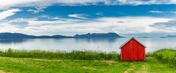 Rotes Haus an einem Fjord in Norwegen - 760589128