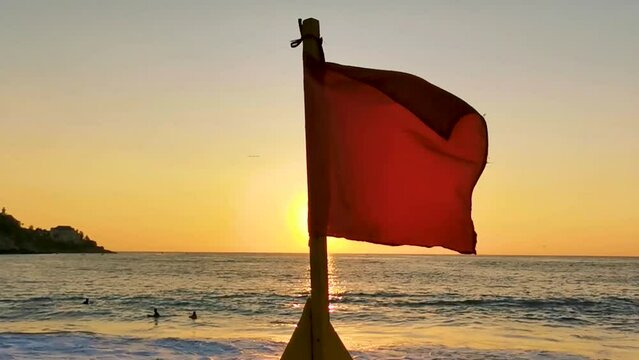 Red flag swimming prohibited high waves with sunset in Mexico.
