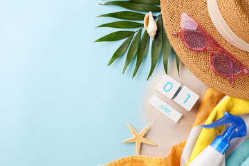 Marking summer days: overhead view of June calendar, straw hat, pink sunglasses, sunscreen bottle,...