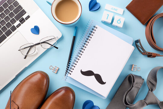 Contemporary Father's Workspace: Overhead View Of Laptop, Stylish Men's Shoes, And Personal Items On A Light Blue Background, Perfect For Father's Day Greetings