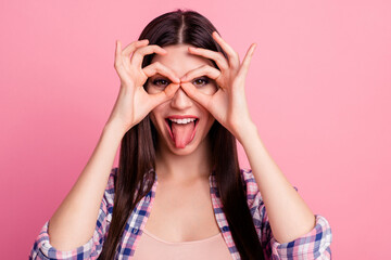 Close up photo amazing beautiful her she lady hold arm hand fingers okey symbol near brown eyes playful mood tongue out mouth wear casual checkered plaid shirt clothes outfit isolated pink background
