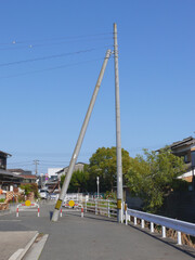 Fototapeta na wymiar 電柱とそれを支えるコンクリート柱。 日本の道路の風景。 日本の住宅街。