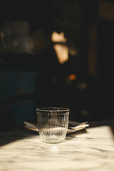 Moody luxury restaurant table setting with water glass