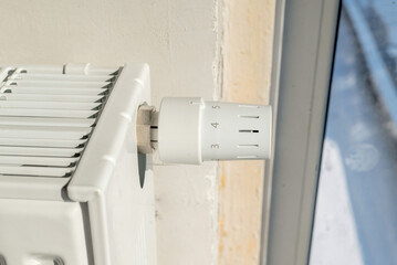 Heating radiator and thermostat in a house under construction in close-up. The heat regulator on the radiator. heat regulation and savings on utility bills