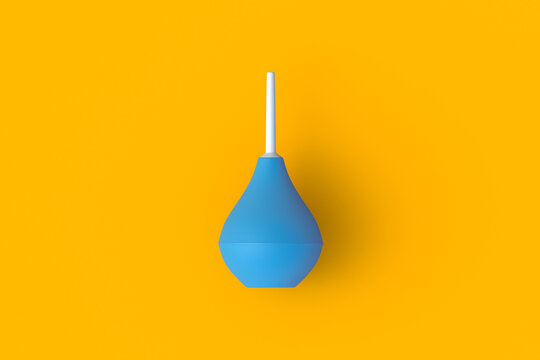 Enema on orange background. Rubber douching bag. Pear shaped syringe bulb. Medical clyster. Nasal aspirator. Laboratory tool. Constipation treatment. Top view. 3d render