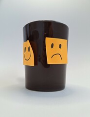 Smiling and frowning faces on a cup