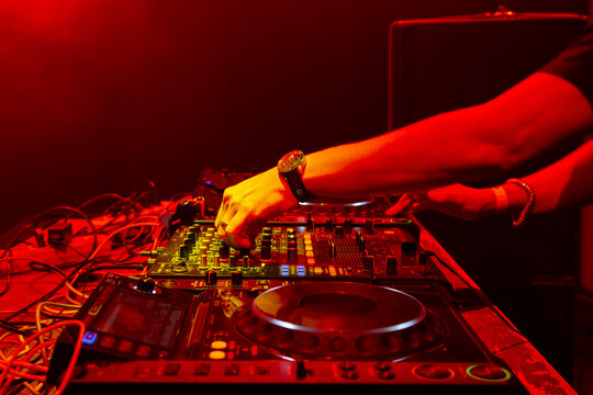 Dj mixes the track in nightclub at party. Body part on the DJ's music control panel