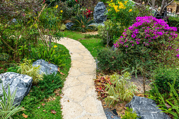 Bright coloured flowers in garden with stone path