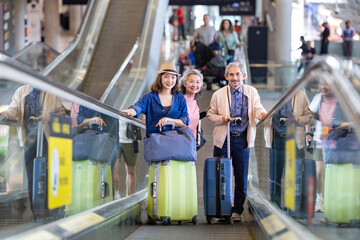 Group of Asian family tourist passenger with senior parent using escalator at the airport terminal for airline travel and holiday vacation