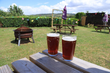 Pints of beer on a picnic bench in a pub garden on a summer’s day
