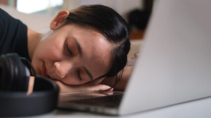 Exhausted sleep deprived stressed female manager lying on table and sleeping after hard working...
