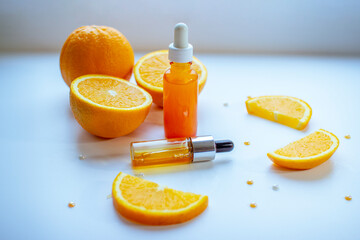 Vitamin C face skin care cosmetic concept - organic serum in a bottle and orange slices on white background