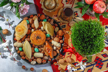 Traditional Azerbaijan holiday Novruz background with green semeni,traditional azerbaijan sweets,shekerbura,qogal,paxlava,mutaki and different nuts and sweets,top view,space for copy