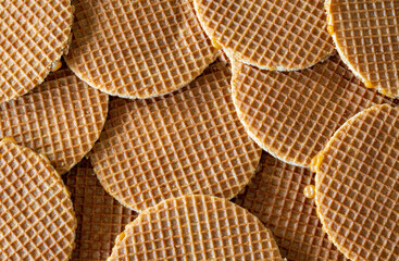 Traditional dutch Stroopwafels spread on the table, texture of  round waffle cookie, top down view