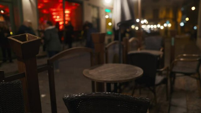 Dim image of tables and chairs in restaurant at night