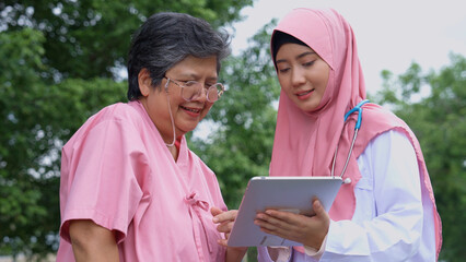 Muslim careful caregivers or doctors hold the tablet to Explain guidelines and treating disease, physical therapy.  Concept of happy retirement with care from a caregiver and senior health insurance.