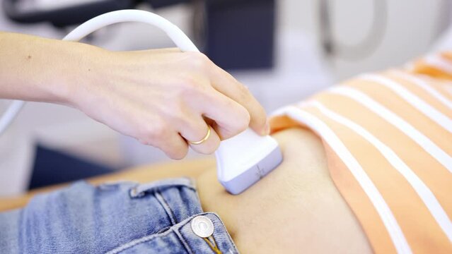 Close-up of doctor performing an ultrasound to pregnant woman