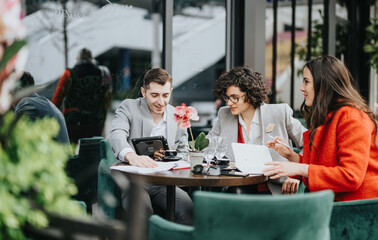 Focused business colleagues at an outdoor cafe engaged in a strategic discussion with documents and a tablet.