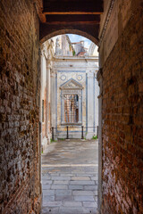 Campo San Giovanni (St John Square) in Venice, with renaissance marble screen erected in 1481, seen from narrow lane - 760693127
