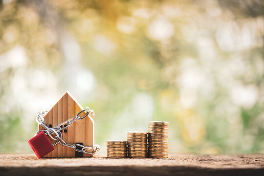 Home model with security and lock and the stack gold coin in public park, Business investment for real estate and or loan for buy house concept.