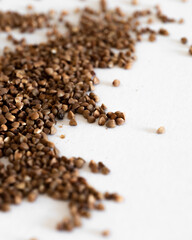 A Pile Of Brown Grains of buckwheat On A White Surface
