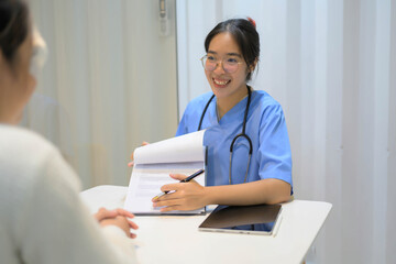 A woman in a blue shirt is talking to a woman in a white shirt