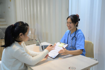 A woman is sitting at a desk with a clipboard in front of her