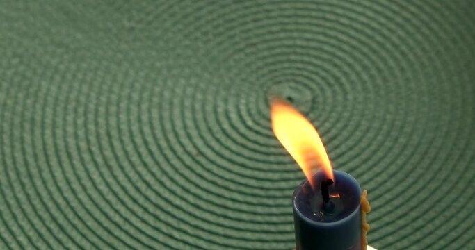 Candle light infront of green background with circles. Symbolic representation of infinite divine presence