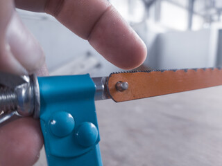 Checking sharpness and showing the correct direction of the hacksaw teeth.