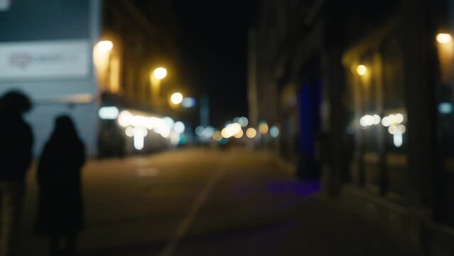 a blurry picture of people walking down a city street at night