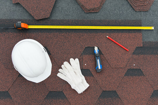 a set of things for laying a soft roof, a knife, gloves, a helmet and a meter
