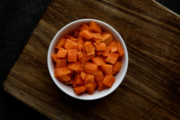 Photograph taken from above of a bowl of chopped carrots ready for a recipe