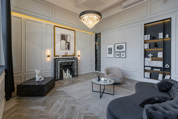 modern living room in a historical style with a marble fireplace in a chic expensive bright interior of a huge apartment without people daytime