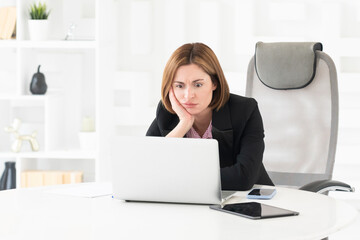 Tired frustrated and overworked business woman sitting in the office and thinking about problems in business	