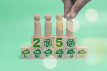 A hand of businessman holding little wood man on 2050 with CO2 reducing icon for decrease carbon...