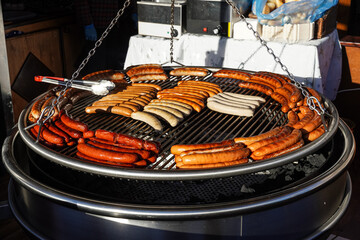 sausages roasting on a large grill