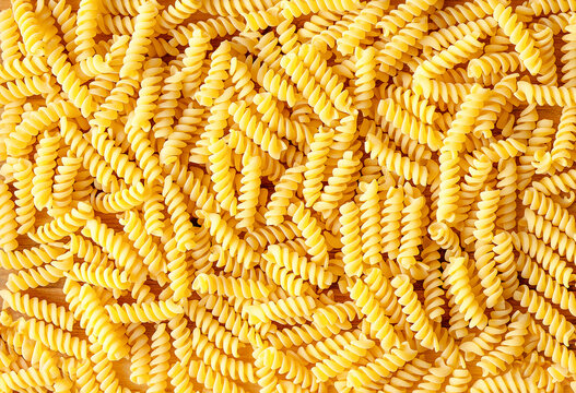 Italian pasta fusilli background. Top view, close up. Close up view at the fusilli pasta Macaroni background or texture