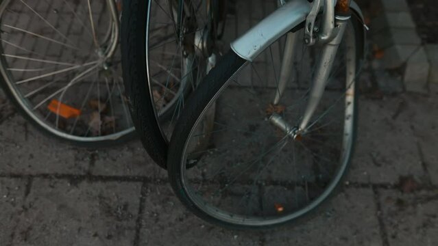 Urban Dilemma: Row of Bikes Parked on Sidewalk with Broken Wheels