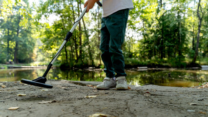 Boy walking in the park with a metal detector