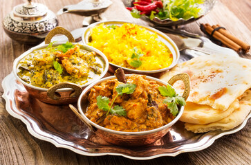 Traditional Indian curry dishes served with saffron rice and pita bread as close-up on a design plate