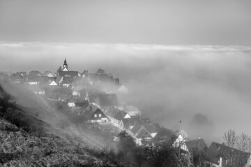 Early spring morning ancient European city shrouded in fog