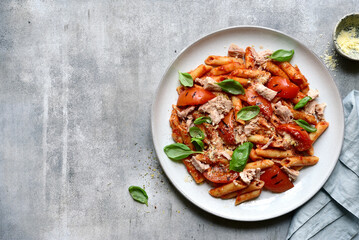Penne pasta with grilled tomatoes and tuna. Top view with copy space.